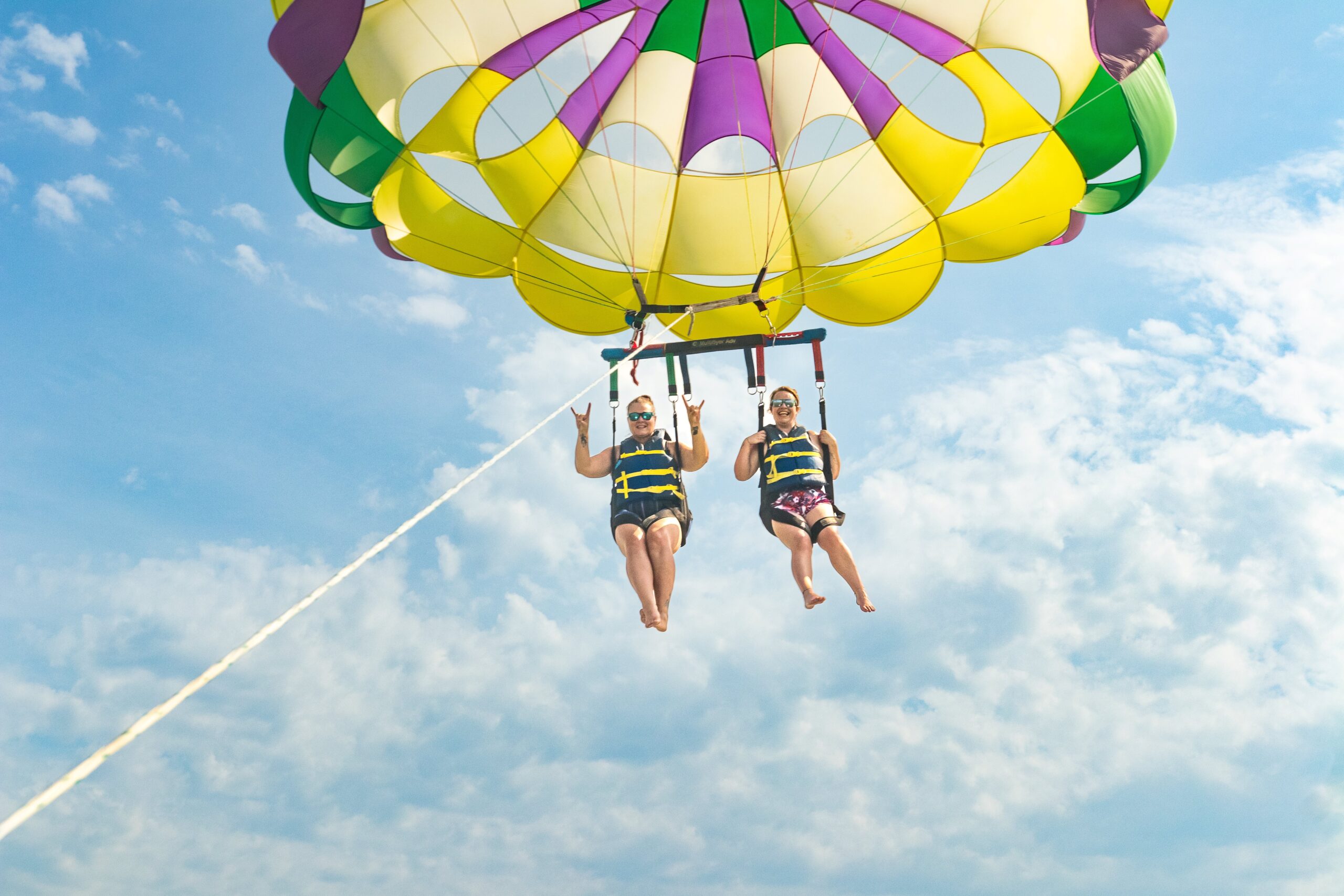 Girls fly with us in Parasailing with hand gestures